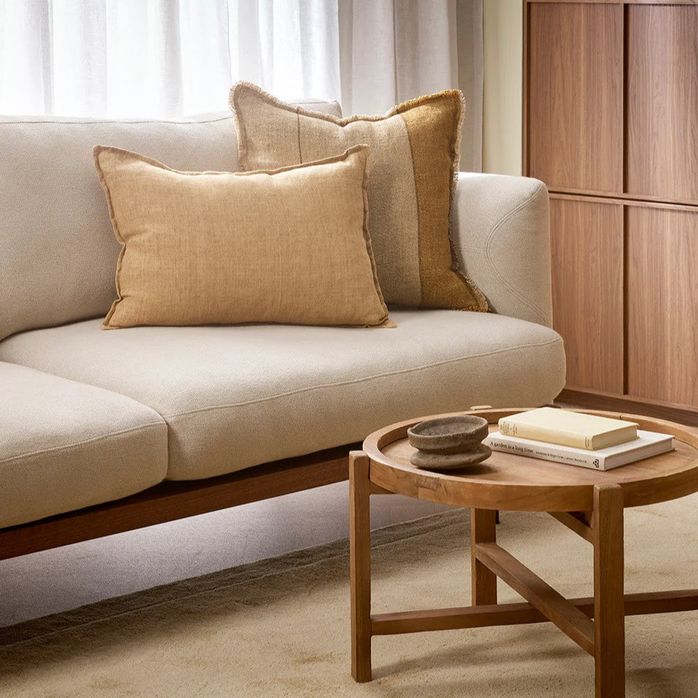 Cumin linen cushion on a Beige sofa with another decorative cushion in a living room setting.