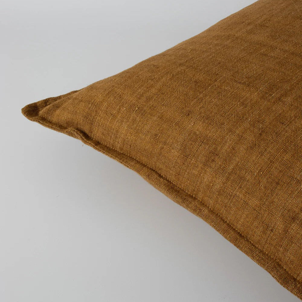 tobacco linen cushion on a light grey background
