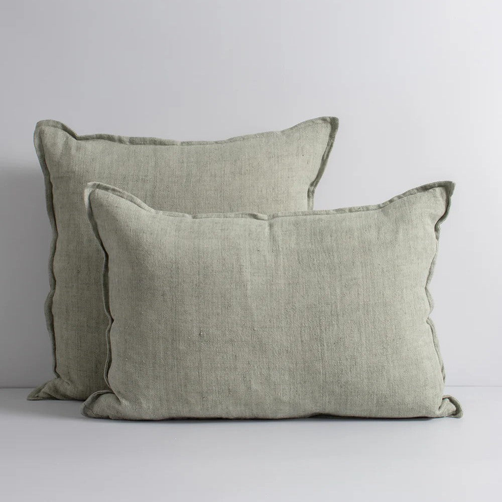 Two sage green linen cushions on a white background