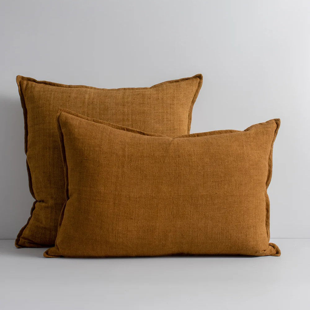 Two tobacco linen cushions on a light grey background