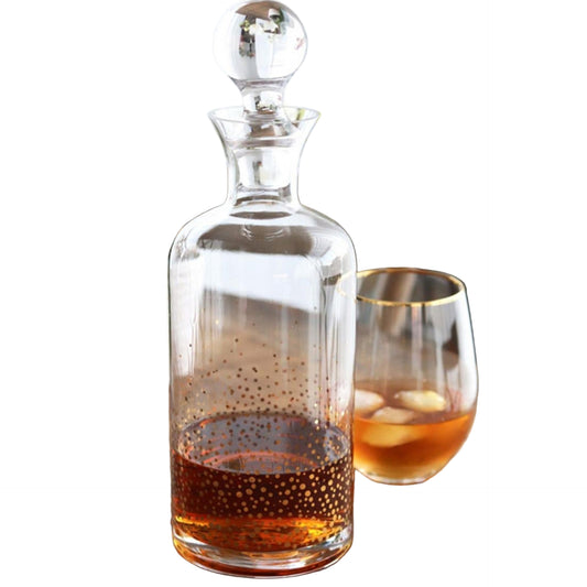 Clear glass decanter with a filled glass on a wooden surface