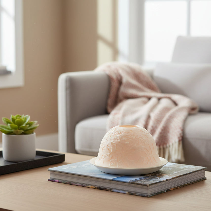 Dome tealight with floral embossing sitting on a book in a living room setting