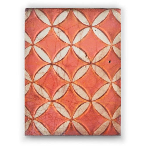 A close-up view of a Sid Dickens Memory Block featuring a geometric pattern with a red and beige color palette.