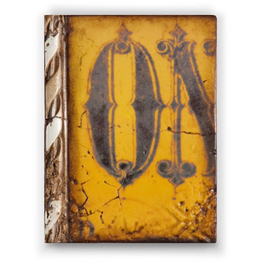 A yellow decorative plaster 'Sid Dickens Memory Block' with a large ornate letter 'O' in the center, designed to resemble a aged looking wall art.