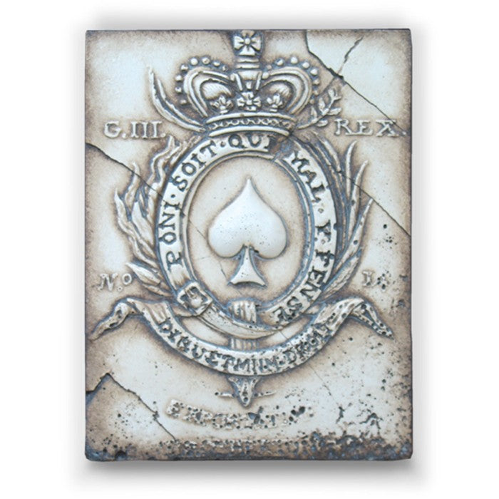 Decorative tile with a spade symbol and crown on a textured background