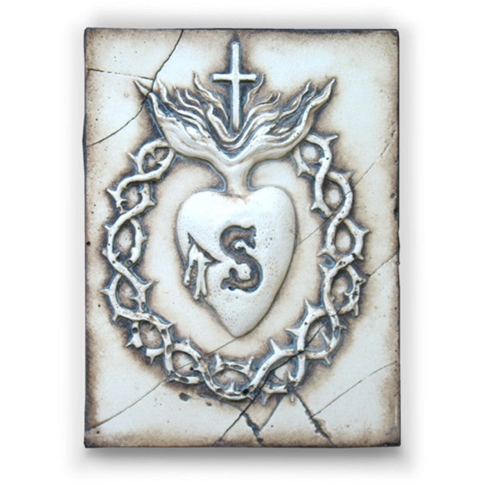 Decorative tile with a heart design, cross, and 'S' on a textured background