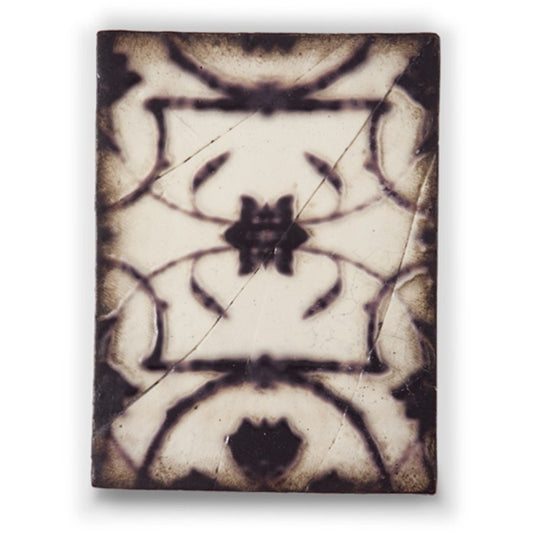 Decorative tile with intricate black and white pattern on a beige background