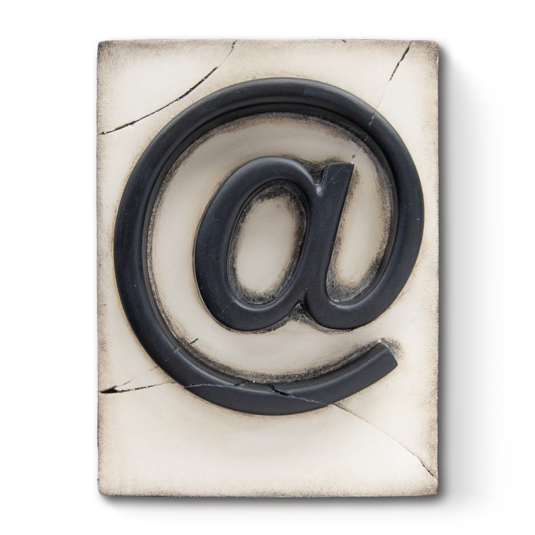 A decorative plaster plaque featuring the symbol 'at' in a cracked black finish, with silver and gold leafing details.