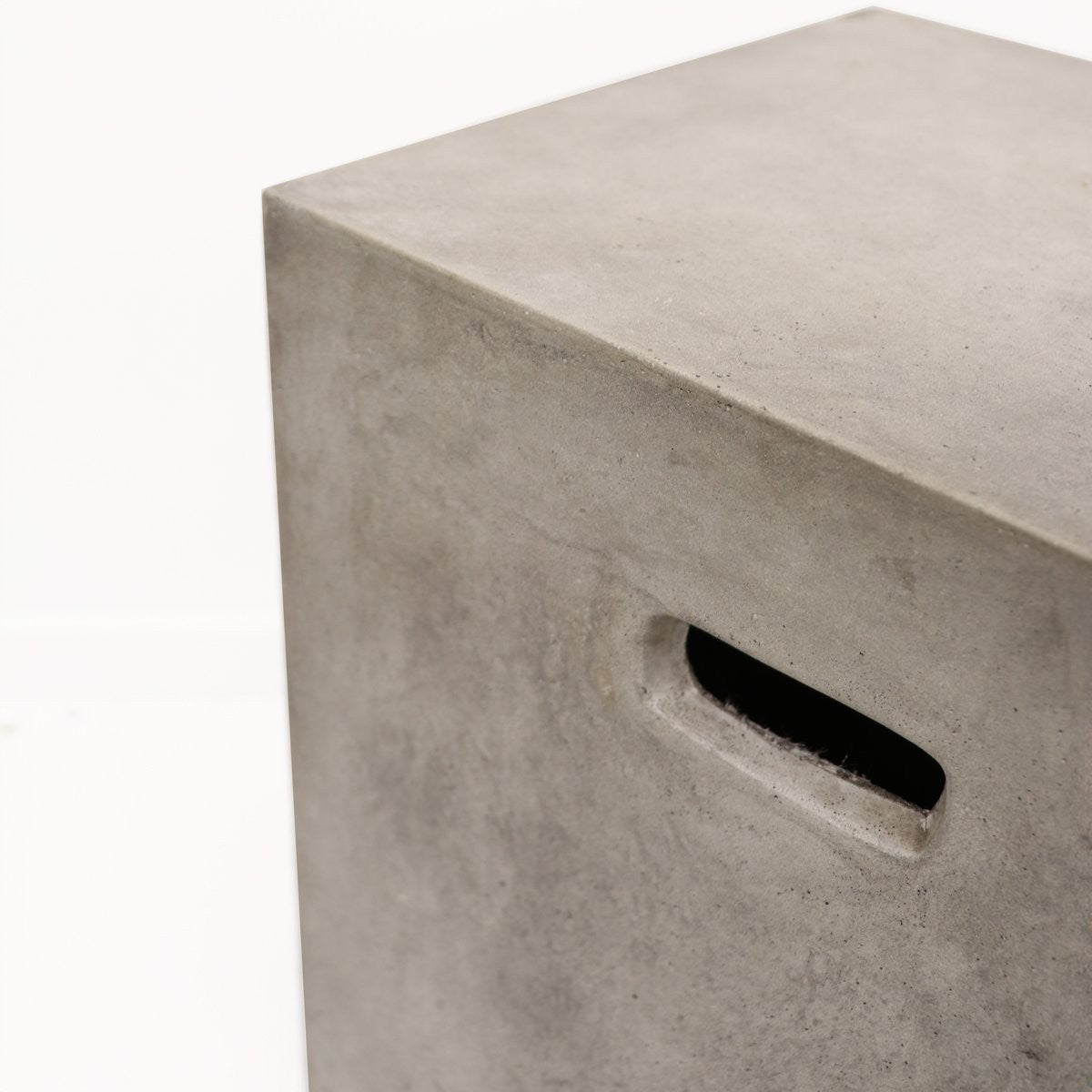 Concrete cube with a rectangular handle hole on a white background