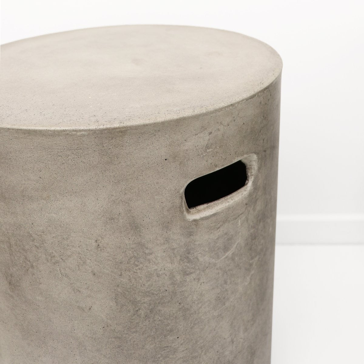 Concrete stool with a circular top and rectangular hole on a white background