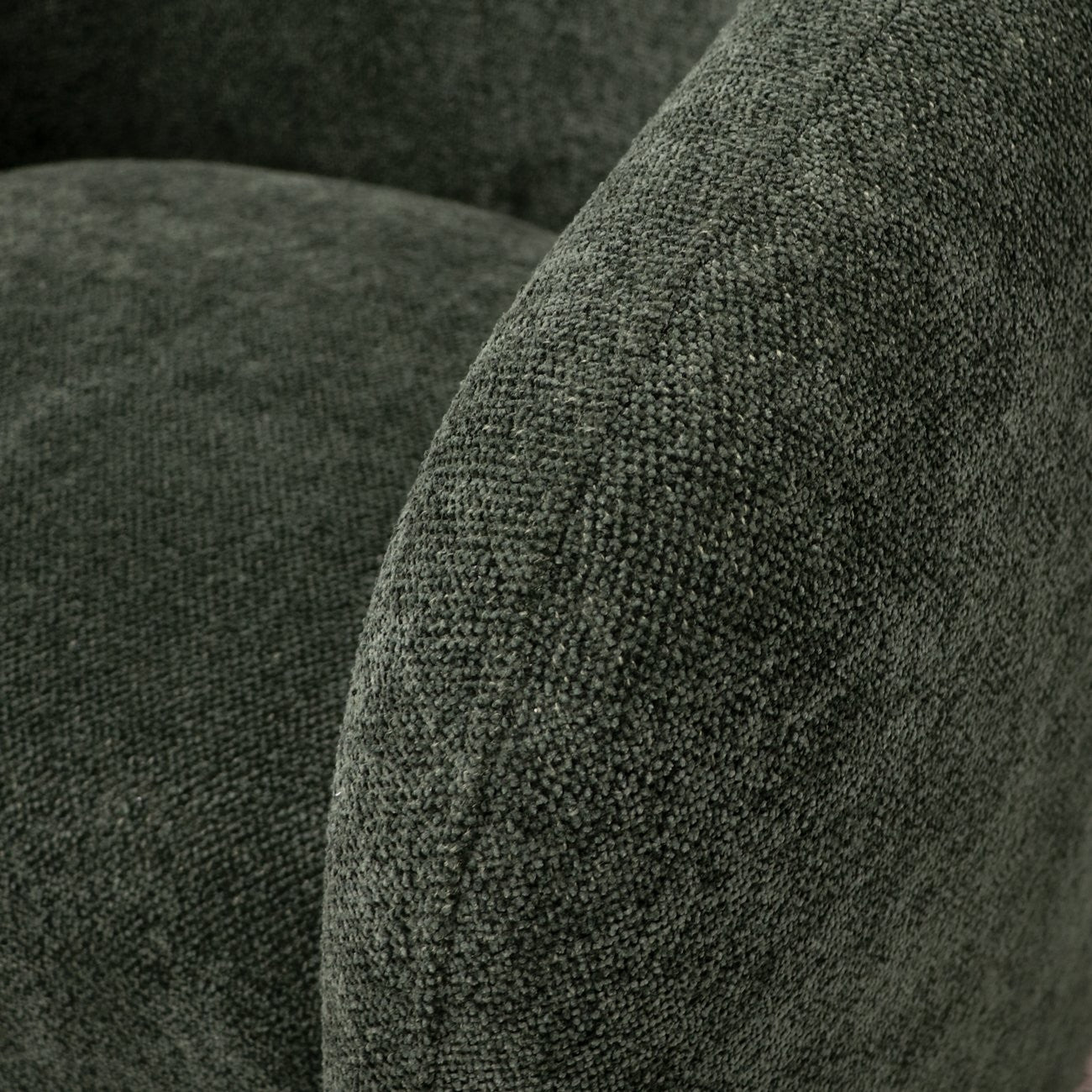 Close-up of textured green fabric surface on a swivel armchair