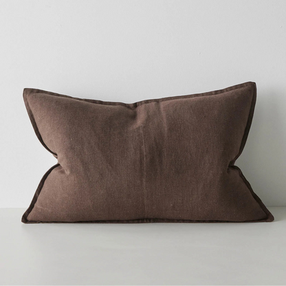 Brown lumbar cushion on a white surface with a light grey background