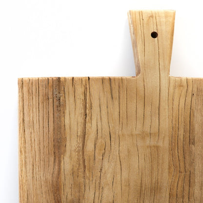 Closeup of wooden serving board with a handle on a white background