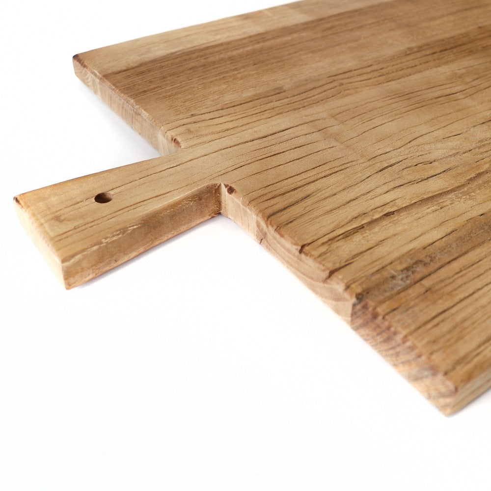 closeup of wooden serving board with a shaped handle on a white background