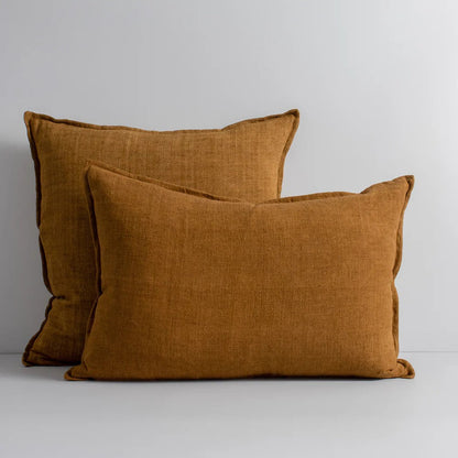 Two tobacco linen cushions on a light gray background