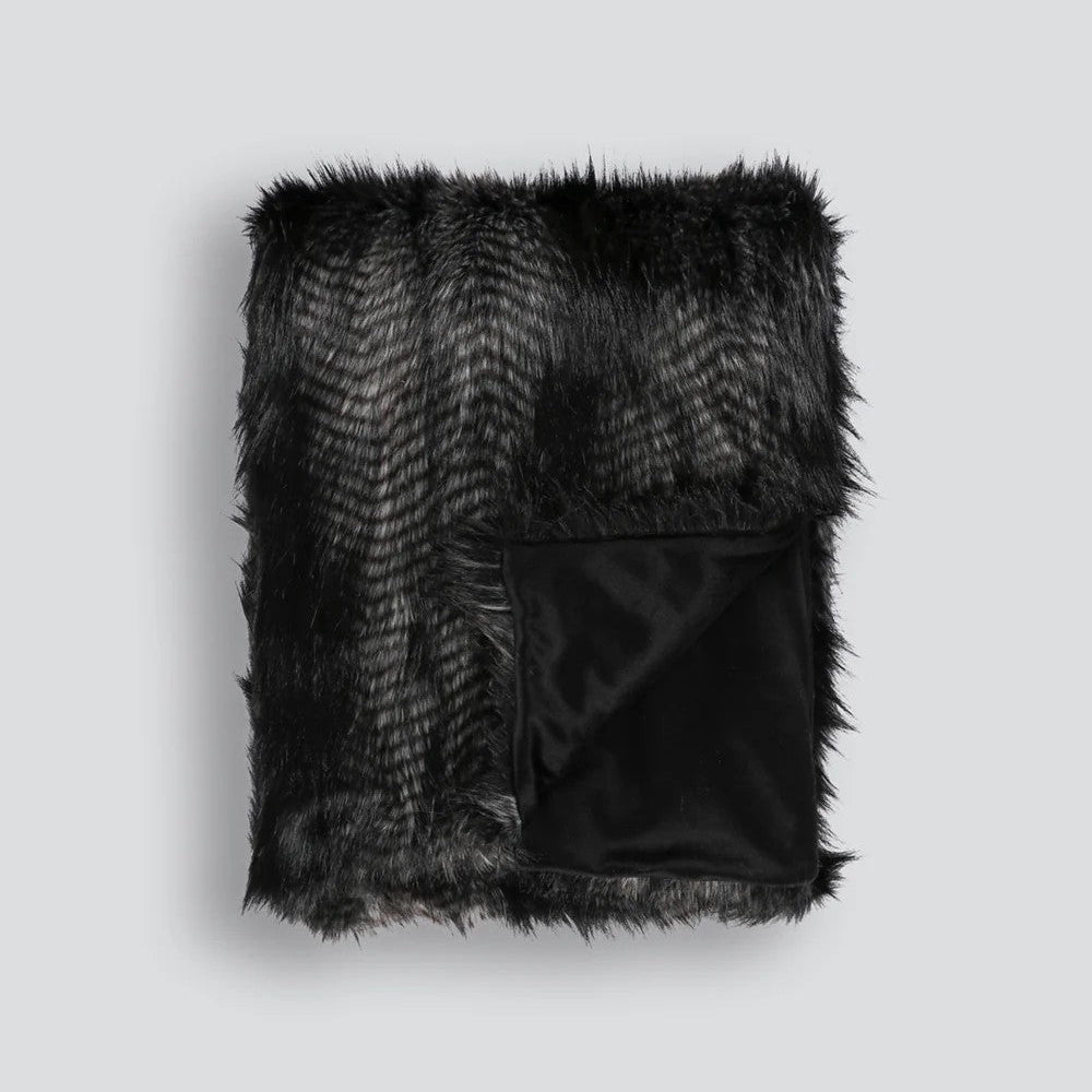 Black Coyote faux fur throw blanket on a white background