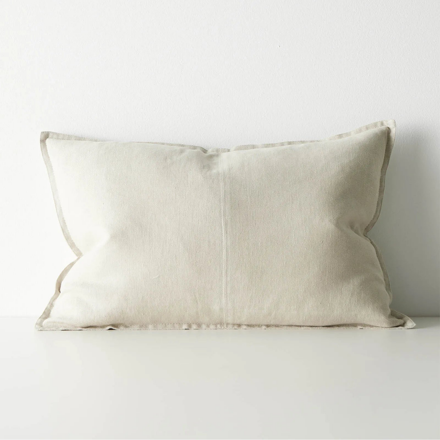 Beige pillow on a white sofa against a white background