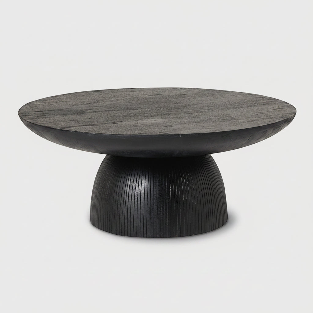 A modern round coffee table with a dark black wood top and a sculptural ribbed pedestal base, shown against a white background.