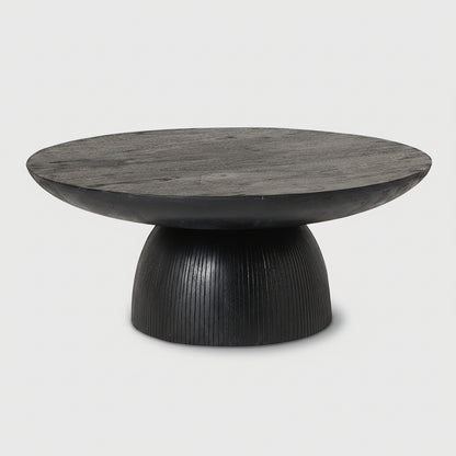 A modern round coffee table with a dark black wood top and a sculptural ribbed pedestal base, shown against a white background.