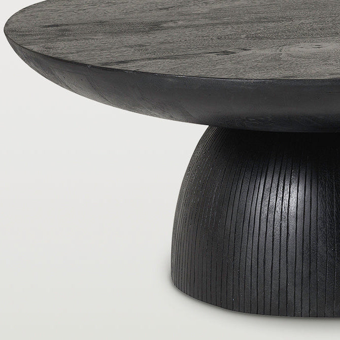 Close-up of a black wood pedestal table with a round top and a ribbed dome-shaped base on a white background.
