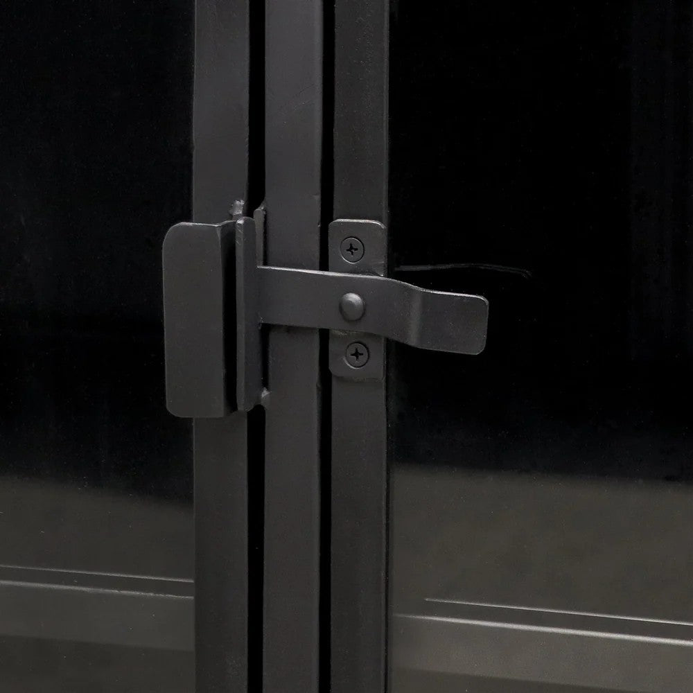 Close-up of a black metal latch and handle mechanism on double glass doors. 