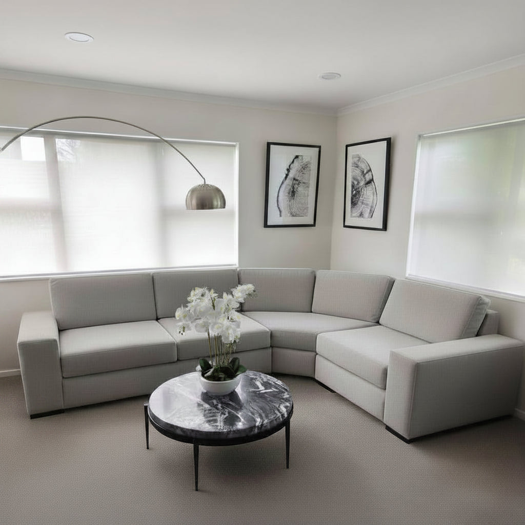 Modern living room with a gray sectional sofa, marble coffee table, and decorative elements.