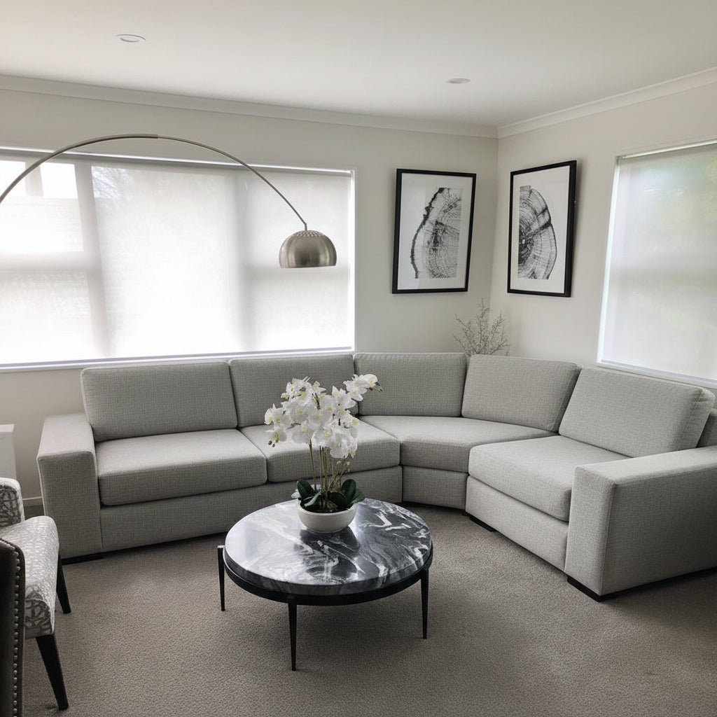 Modern living room with a gray sectional sofa, marble coffee table, and decorative elements.