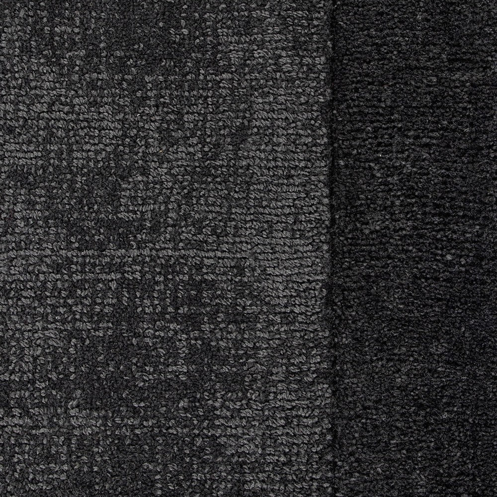 Close-up of charcoal textured floor rug with a border detail.