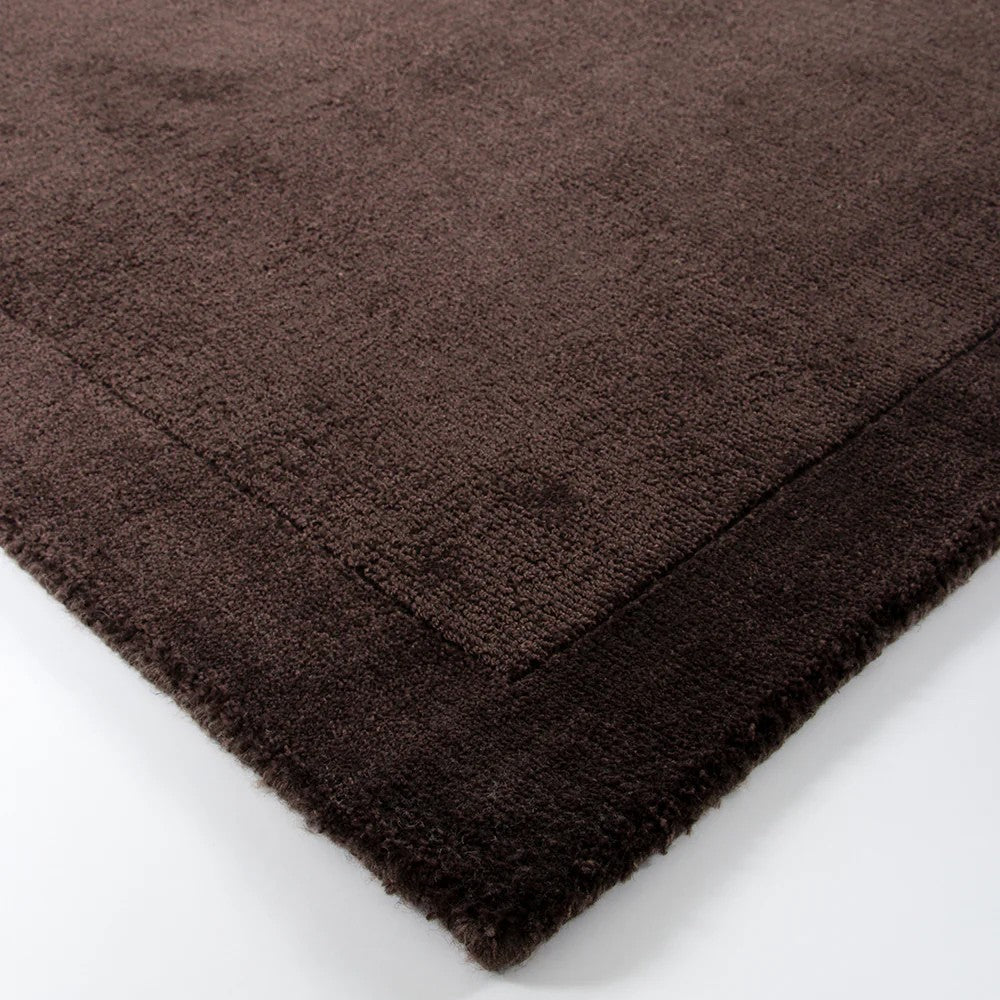 Close up of chocolate brown floor rug on a white background