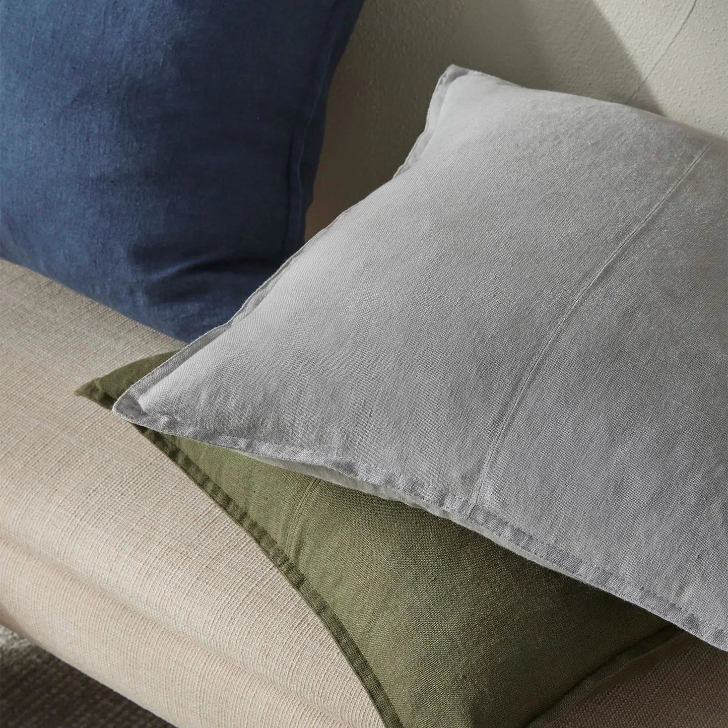 Grey and green cushions on a beige sofa