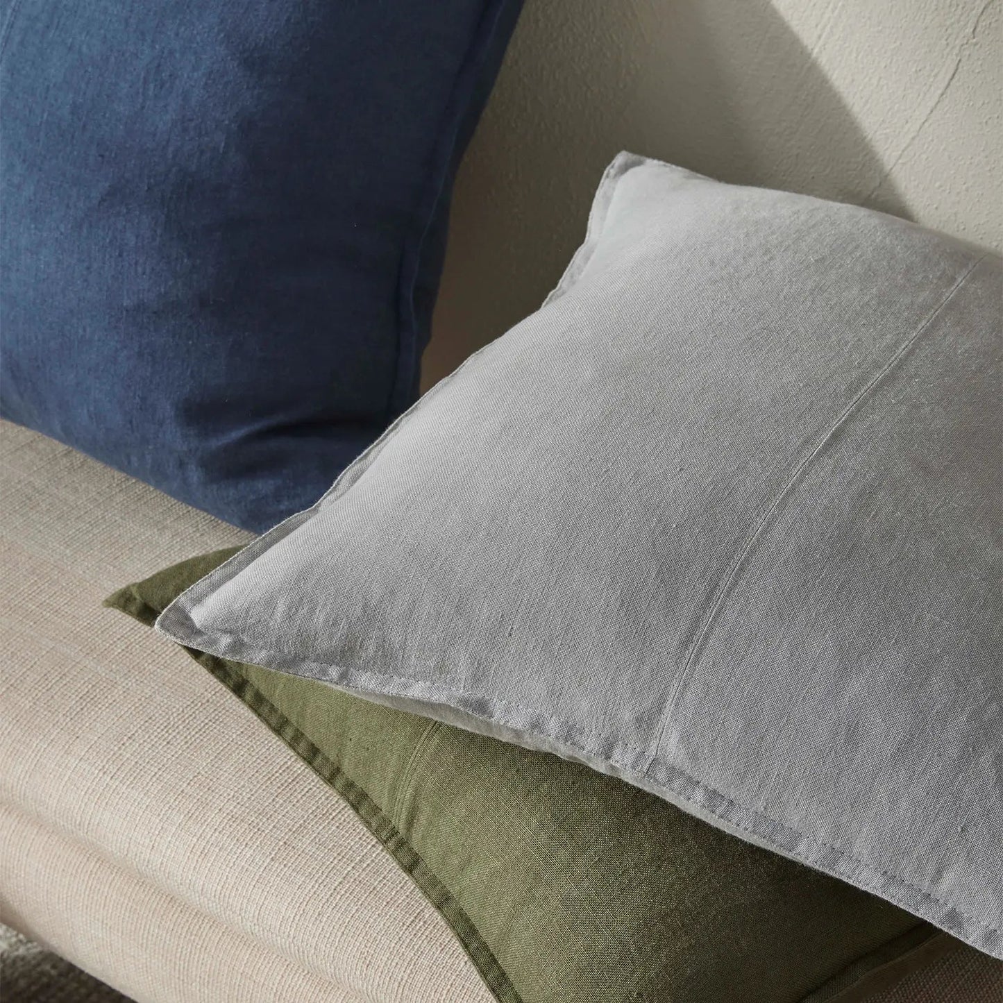 Gray and green pillows on a beige sofa