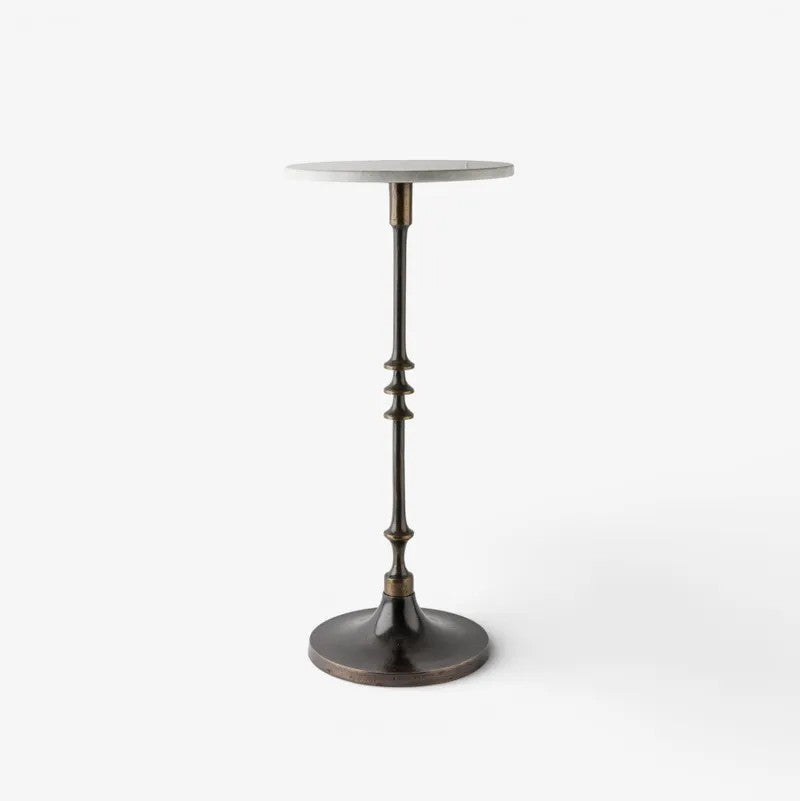 A modern pedestal side table featuring a round white marble top and a dark bronze metal stem with decorative fluted details and a circular base, shown on a clean white background.