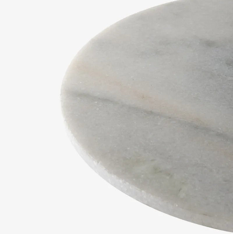 Close up of round white marble table top with a subtle pattern on a white background