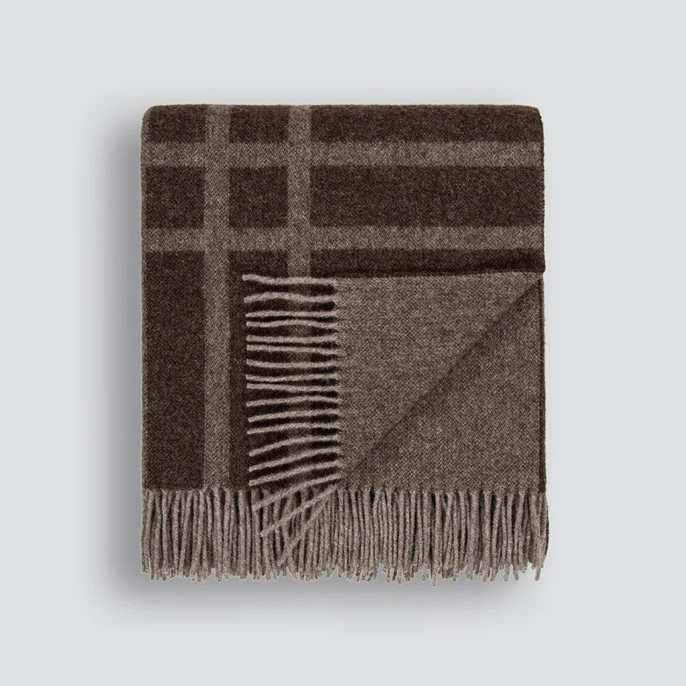 A folded brown plaid wool blanket with fringed edges, displayed on a white background.