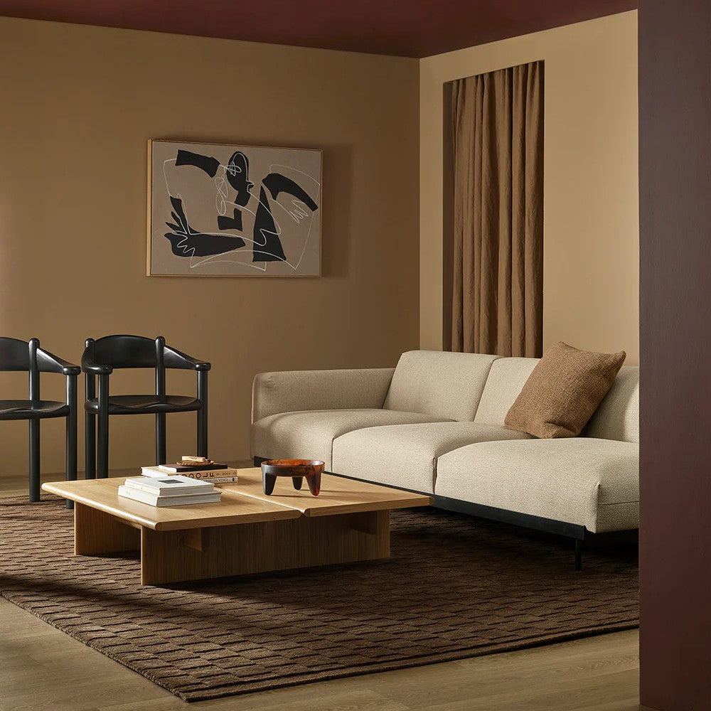 Modern living room with beige sofa, wooden coffee table, espresso coloured floor rug and abstract art on wall.