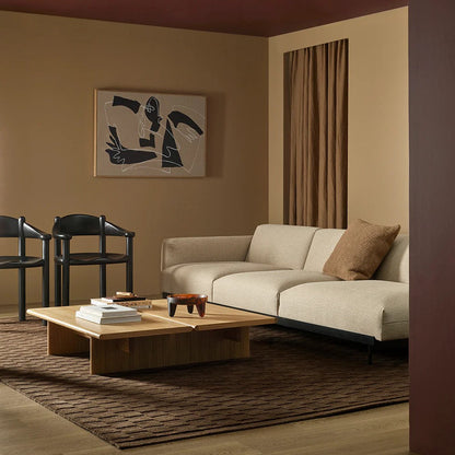 Modern living room with beige sofa, wooden coffee table, espresso coloured floor rug and abstract art on wall.