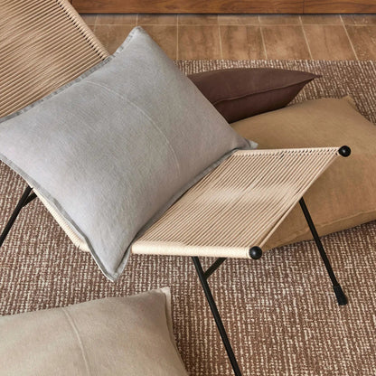 Small table with a gray cushion on a textured floor