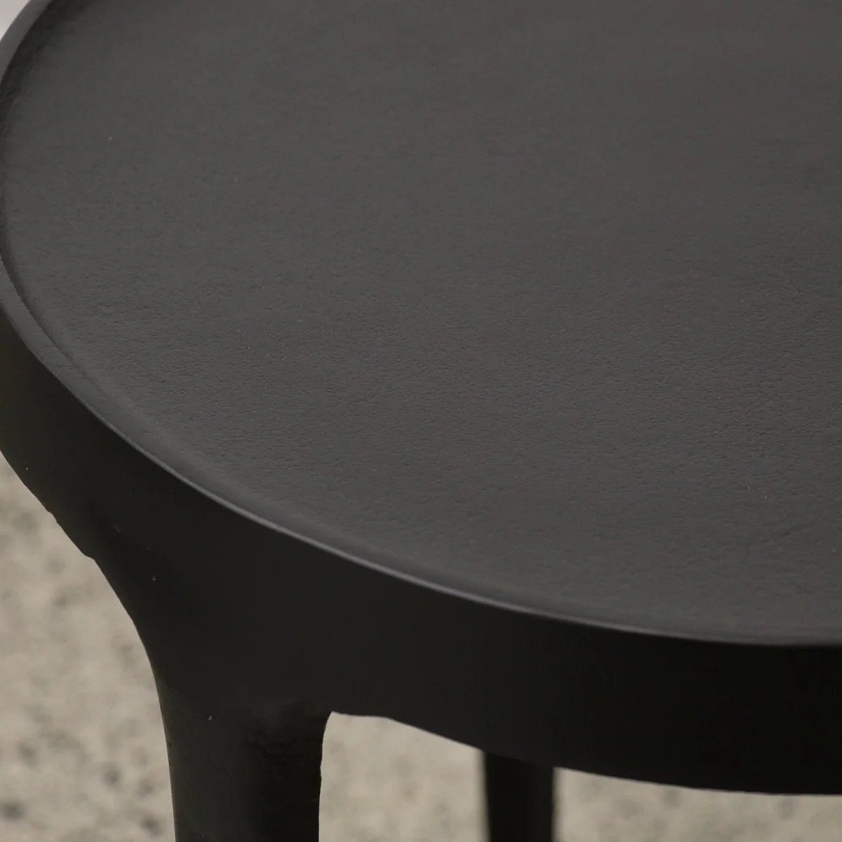Close-up of a black side table with a textured surface.