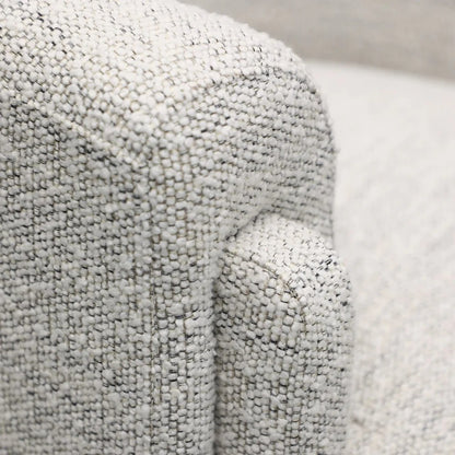 Close-up of textured cream fabric on an armchair 