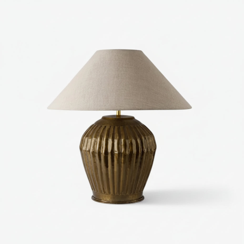 Table lamp with ribbed textured base and linen shade on a white background