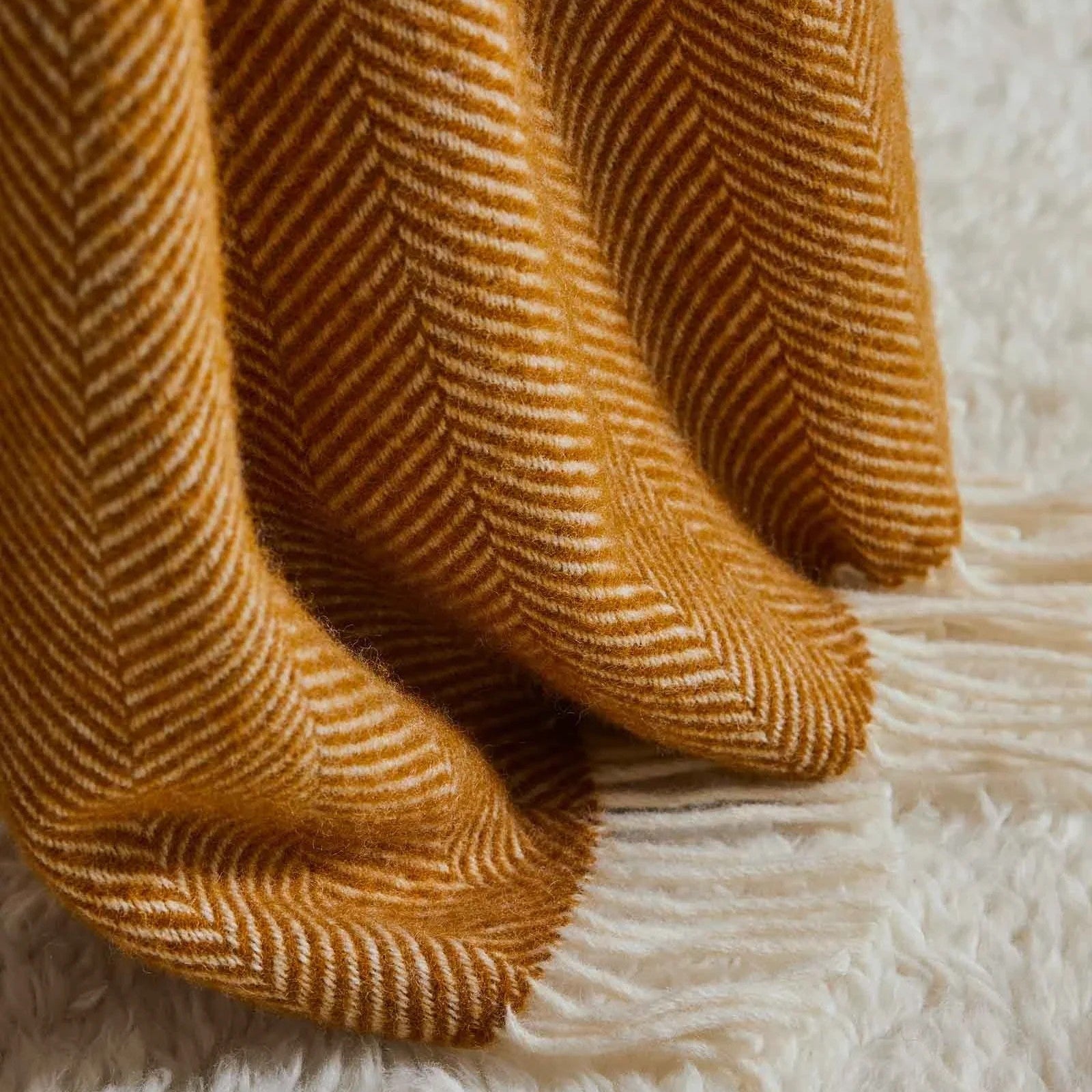 Close-up of a textured Amber Throw blanket on a white surface