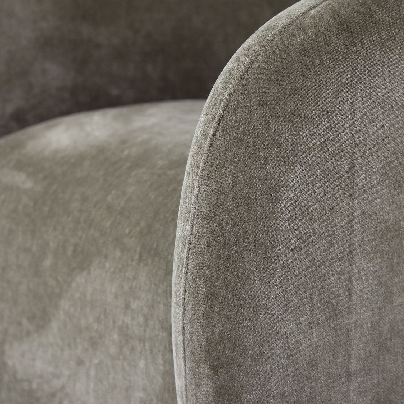 Close-up of a moss upholstered chair with a textured fabric surface.