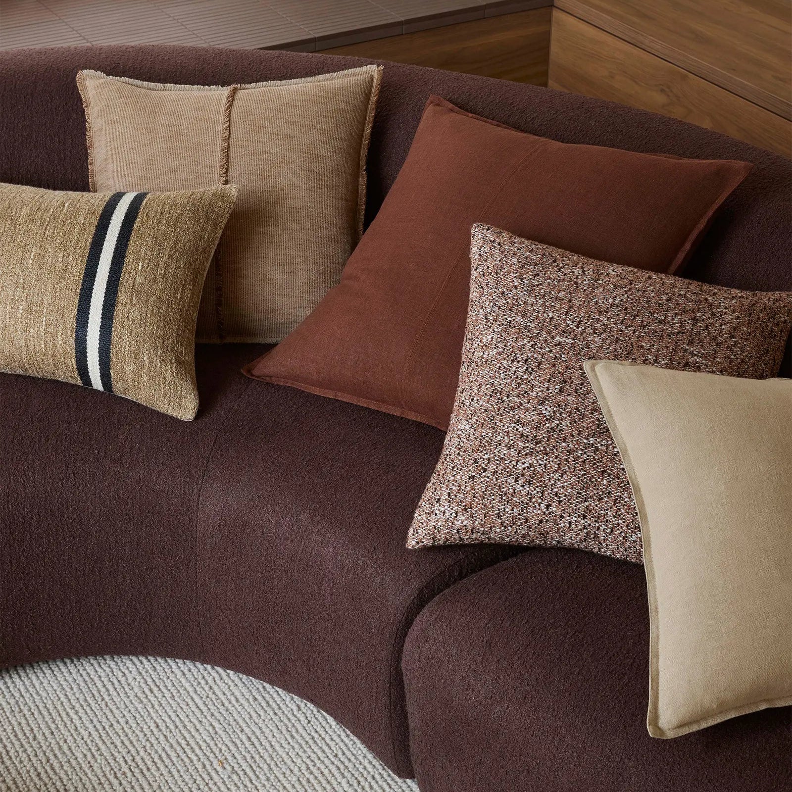 Brown sofa with patterned cushions in a room setting