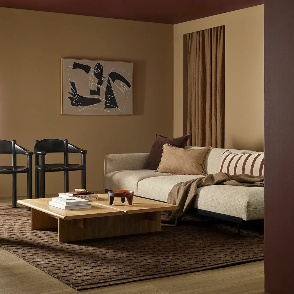 Modern living room with a beige sofa, wooden coffee table, and abstract art on the wall.