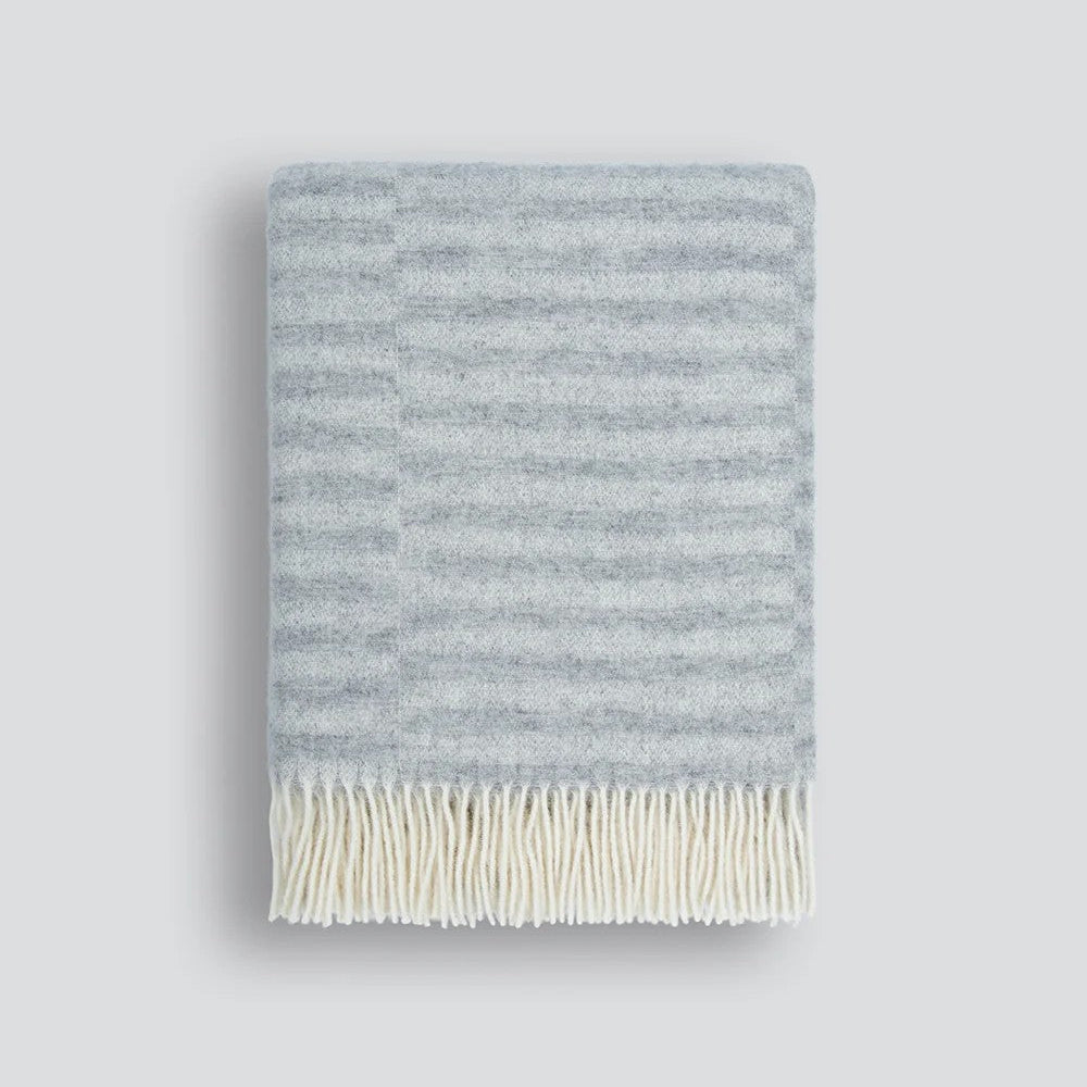Striped silver grey throw blanket on a white background