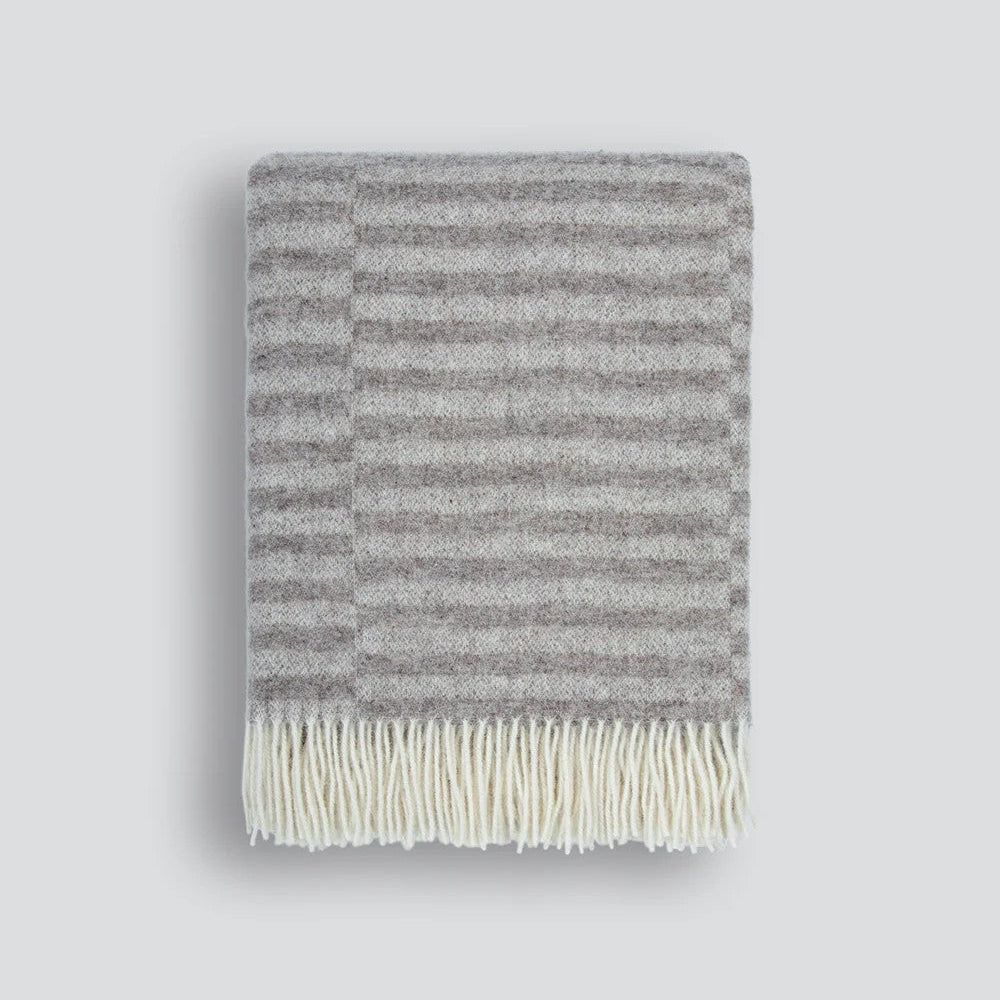 Oatmeal striped blanket with cream fringe on a white background