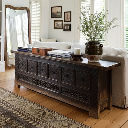 Living room with a dark wooden console table, white sofa, and decorative elements.