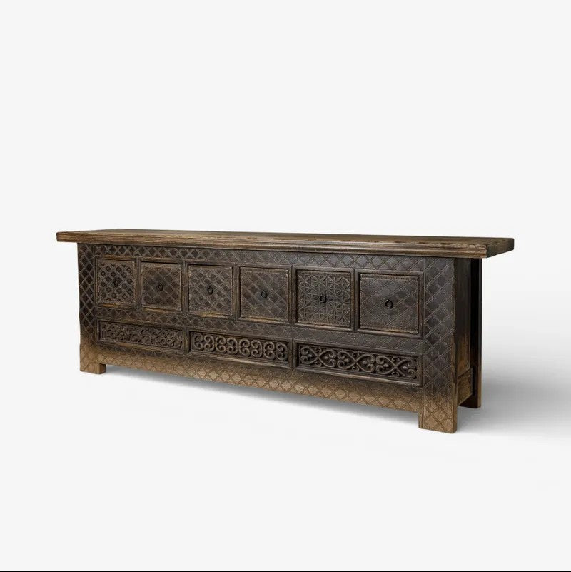 Decorative low wooden cabinet with intricate carvings on a white background