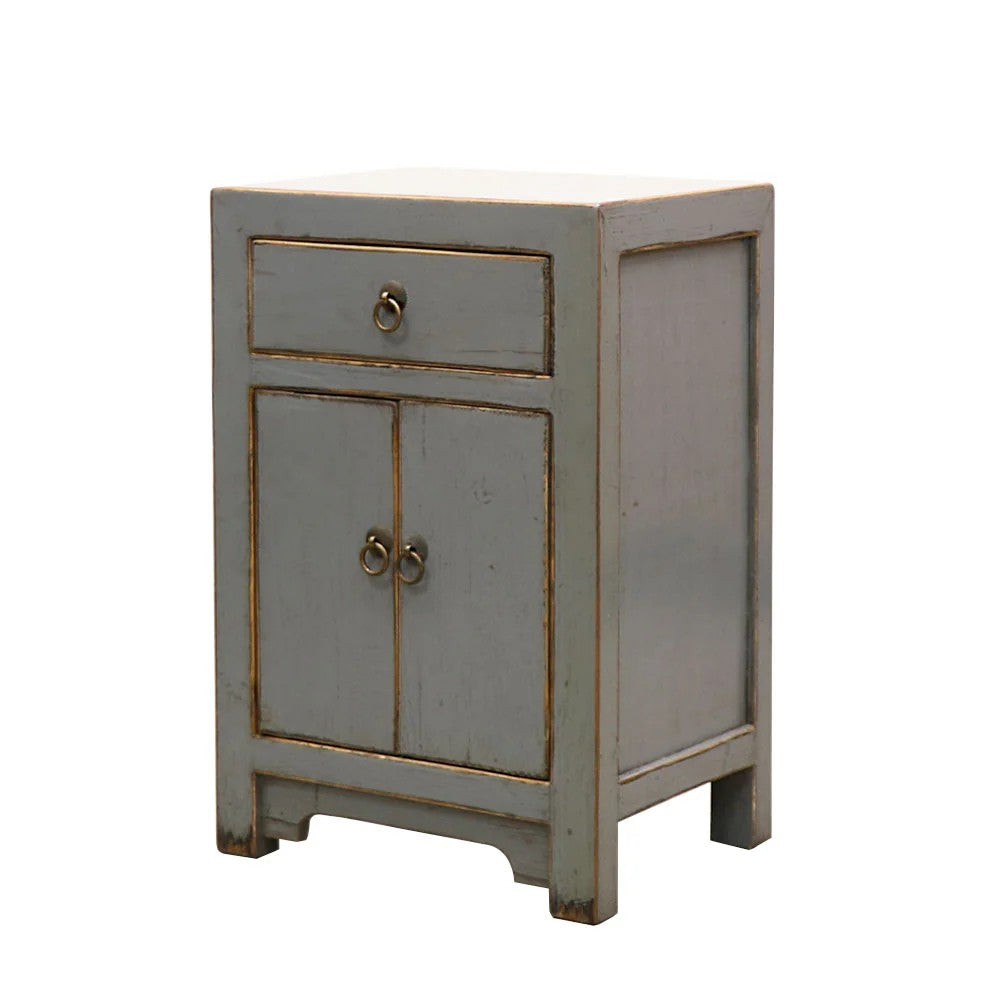 A small grey painted cabinet with a distressed finish, featuring a single drawer on the upper half and two doors on the lower half, with ring pulls, shown on a plain white background