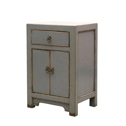 A small grey painted cabinet with a distressed finish, featuring a single drawer on the upper half and two doors on the lower half, with ring pulls, shown on a plain white background